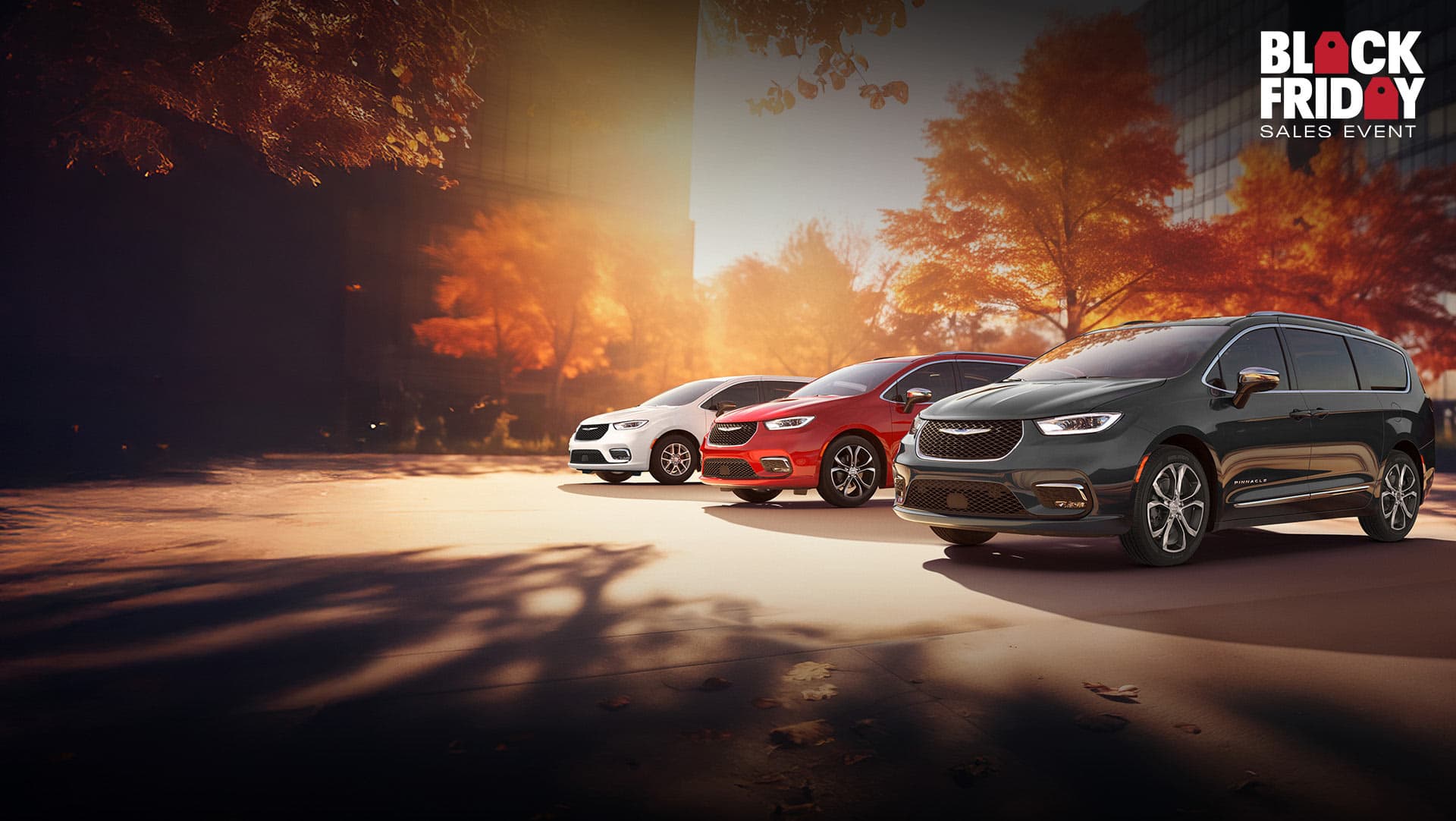 Three 2026 Chrysler minivan models parked on an oceanside beach. From left to right: a white Chrysler Voyager, a blue Pacifica Pinnacle Plug-in Hybrid and a red Pacifica Pinnacle. Black Friday Sales Event.