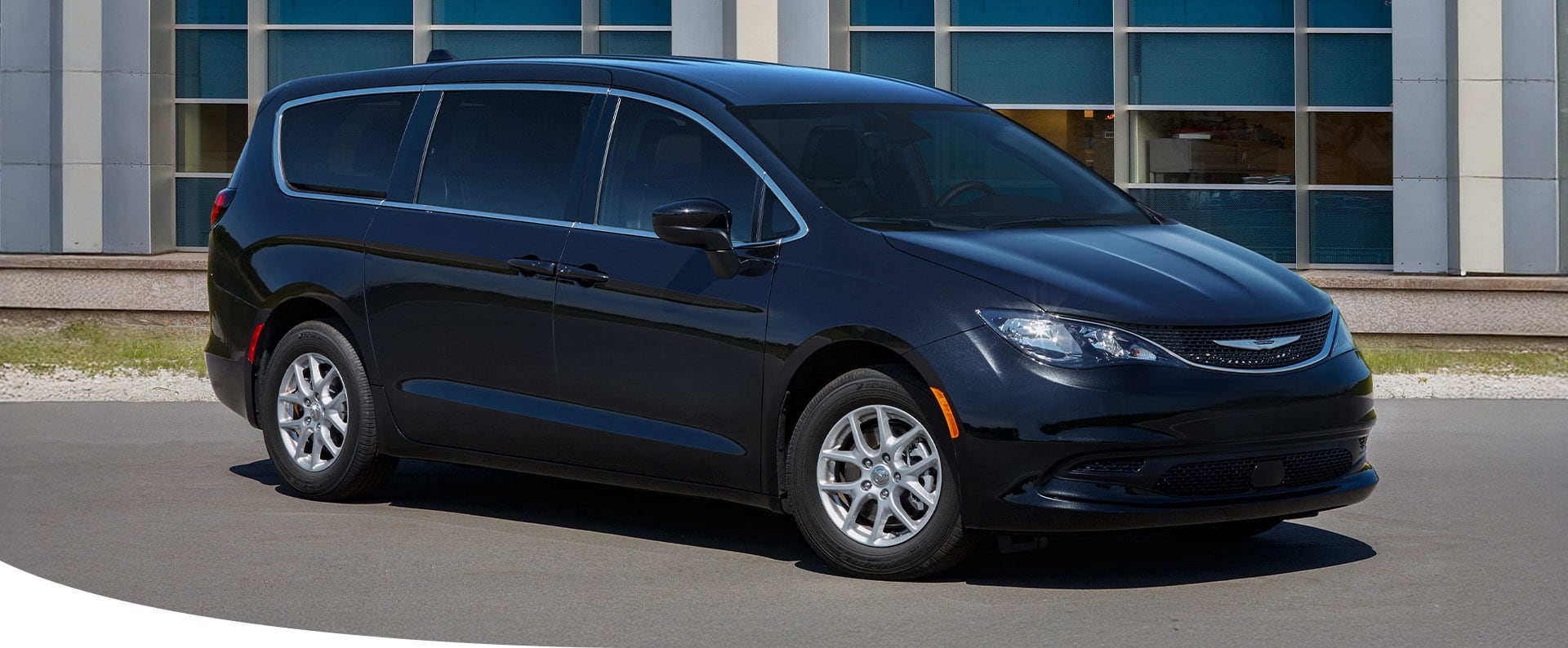 A passenger-side front angle of a black 2025 Chrysler Voyager LX