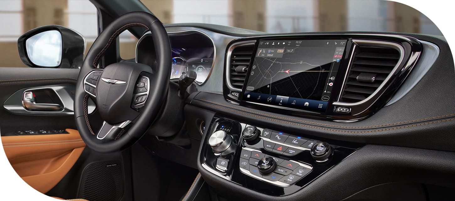 The front row in the 2026 Chrysler Pacifica Plug-in Hybrid Pinnacle, including the steering wheel, Digital Cluster Display, Uconnect touchscreen and center stack controls.