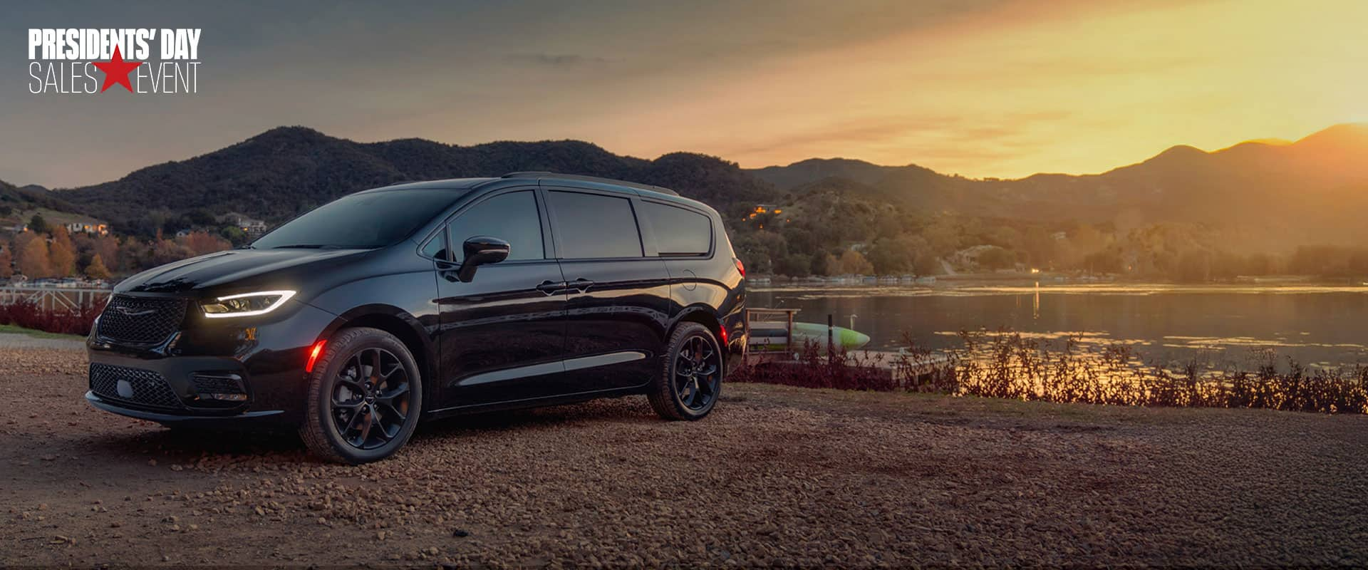 A black 2025 Chrysler Pacifica Limited parked by a lake at sunset. Presidents' Day sales event. 