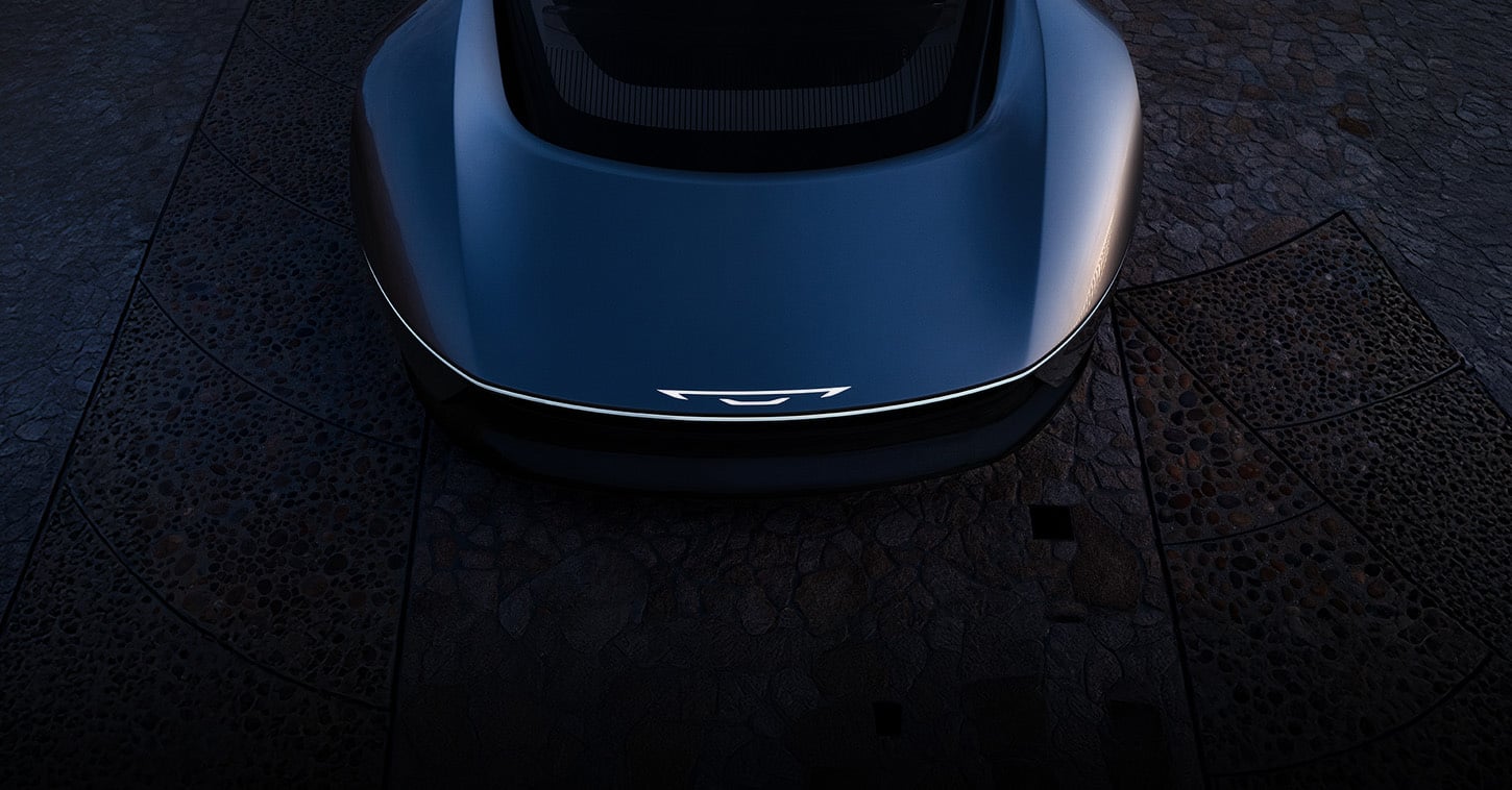 A raised front angle of a gray Chrysler Halcyon Concept vehicle parked in a darkened courtyard.